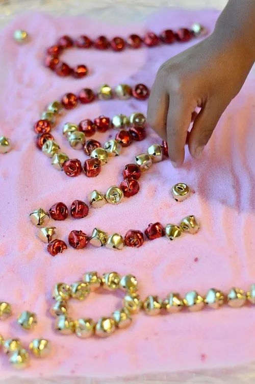 fine motor practice using jingle bell tray