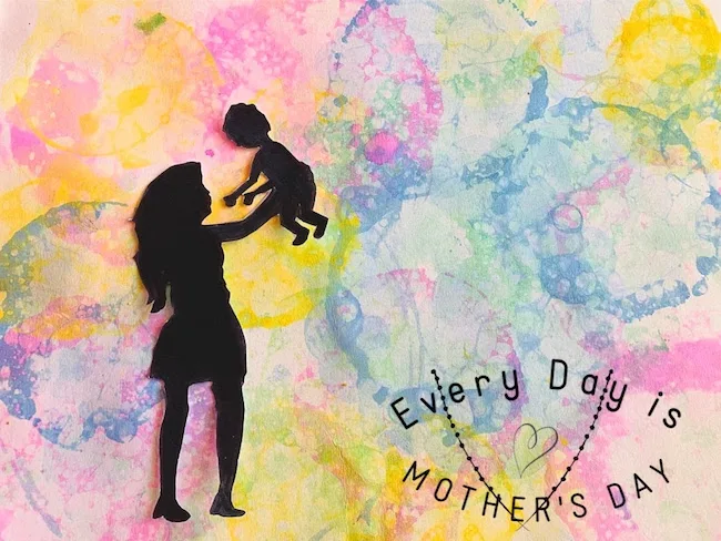 “Every Day is Mother’s Day”: a paper silhouette of a mom lifting her little one, on bubble-painted paper
