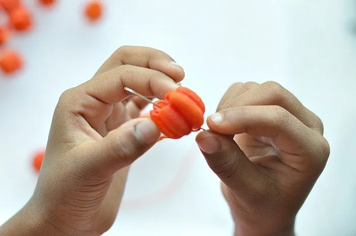 fine-motor-skills-building-with-pumpkin-pasta-threading
