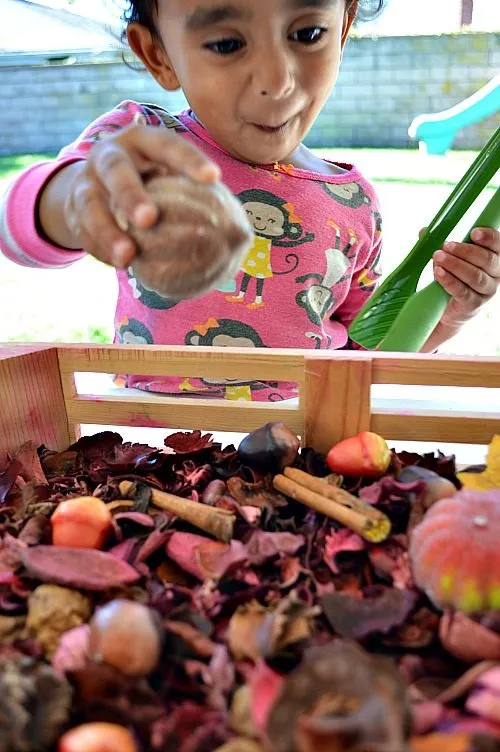 toddler smellng the bin