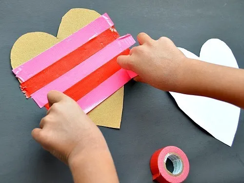 taping duct tape to hearts for valentine art