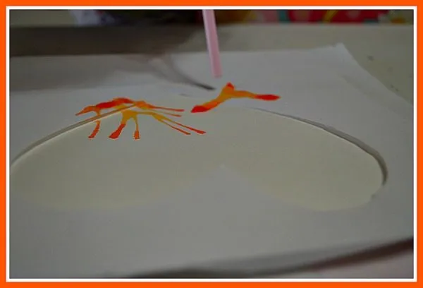 straw blown art with orange paint